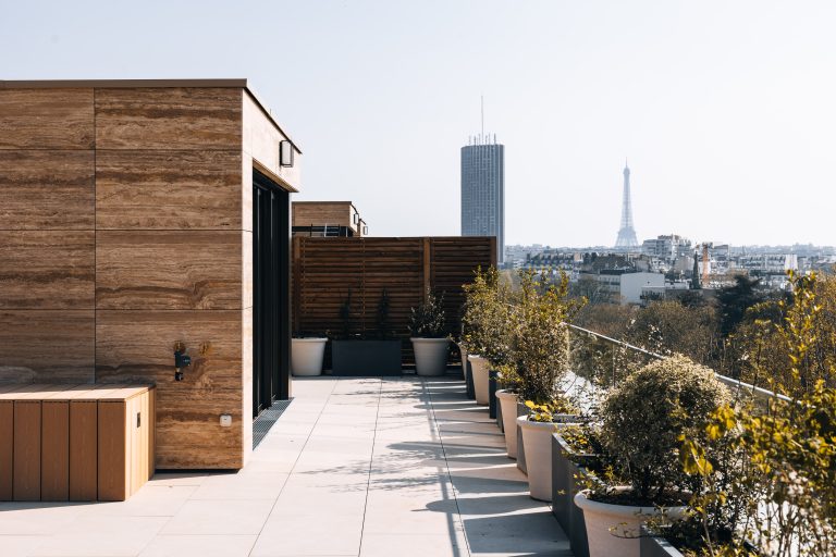 Terrasse d'exception avec vue panoramique sur la Tour Eiffel et la Tour Montparnasse, am&eacute;nagement paysager et dalles de pierre claire. par Maxime Decarsin Photographe