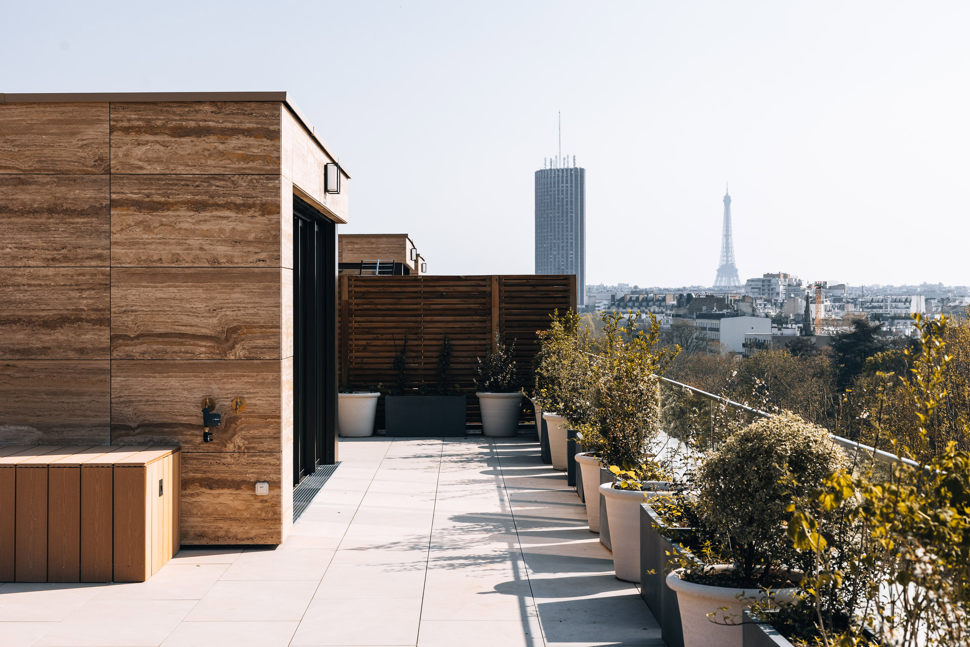 Terrasse d'exception avec vue panoramique sur la Tour Eiffel et la Tour Montparnasse, am&eacute;nagement paysager et dalles de pierre claire. par Maxime Decarsin Photographe