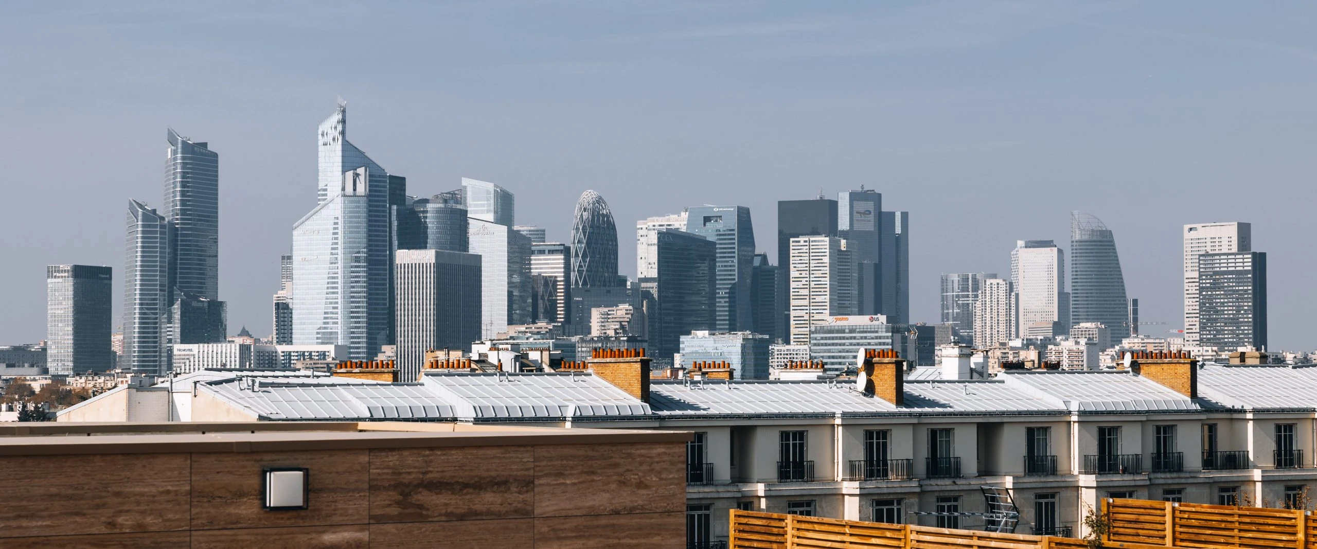Toit-terrasse de luxe Paris : aménagement extérieur haut de gamme offrant une vue panoramique sur la skyline de La Défense.