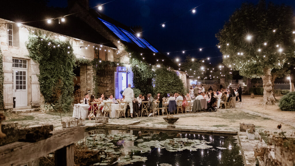 Soirée de mariage éclairée dans la cour du Moulin de Launoy